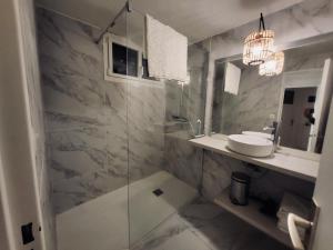 a bathroom with a glass shower and a sink at VILLA BORD DE MER 6 COUCHAGES AVEC JARDIN ET GARAGE in La Grande-Motte