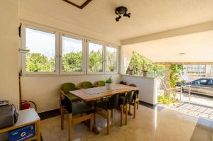 a dining room with a table and some windows at Apartments Mrvelj in Gdinj
