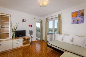 a living room with a couch and a television at Apartments Mrvelj in Gdinj