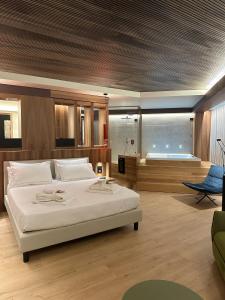 a bedroom with a large bed and a tub at Alevic Hotel Sirmione in Sirmione +37 photos