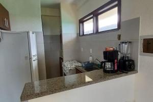 a kitchen with a counter top and a refrigerator at Apartamento à beira-mar. Beachfront apartment in São Gonçalo do Amarante