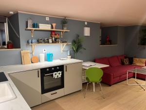 Il comprend une cuisine et un salon avec un canapé rouge. dans l'établissement Brand new flat, parking!, à Bergen