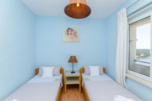 a room with two beds and a window at Apartments Mrvelj in Gdinj