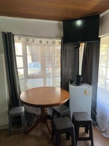 a table and chairs in a room with a television at Cabañas Antonella Los Angeles in Los Ángeles