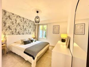 um quarto com uma grande cama branca e uma janela em Appartement de standing avec jardin em La Croix-Valmer