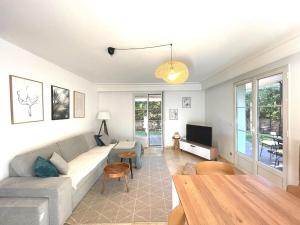 uma sala de estar com um sofá e uma mesa em Appartement de standing avec jardin em La Croix-Valmer