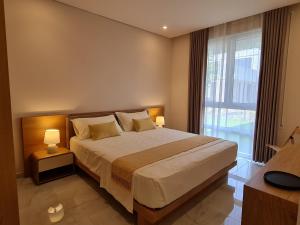 - une chambre avec un grand lit et une grande fenêtre dans l'établissement Gjiri i Lalzit - San Pietro - Savita Premium Apartments, à Durrës