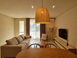 - un salon avec un canapé et une table dans l'établissement Gjiri i Lalzit - San Pietro - Savita Premium Apartments, à Durrës