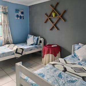 Cette chambre comprend 2 lits et une table. dans l'établissement Zufike Pondoland Wild Coast- Port Grosvenor, à Lusikisiki
