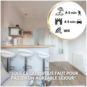 a picture of a kitchen with a counter and stools at Allen - 2min de la plage du sillon et intra in Saint Malo