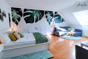 ミュンヘンにあるHOMELY STAY - Serenity Greens Studioのベッドルーム1室(壁に葉が描かれたベッド1台付)