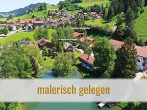 una vista aérea de un pueblo con una casa y un lago en Kranzegger Bergheimat en Rettenberg