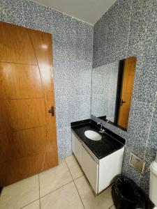 a bathroom with a sink and a mirror at POUSADA BRASÃO in Governador Valadares