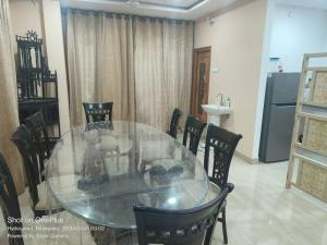a glass table and chairs in a room at Sakez Homestays in Hyderabad