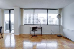 an empty living room with a desk and windows at Spacious & Comfortable Condo at Crystal City in Arlington