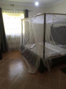 a bedroom with a bed covered in mosquito net at Annex in Kakamega