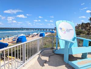 una sedia blu seduta su un balcone con vista sulla spiaggia di Ranch Style, King Bed, Guitar, BBQ- 1 Dollar rides to Beach & Downtown a Lake Worth Altre 40 foto