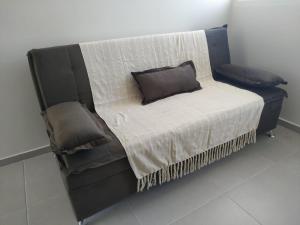 Una cama con marco negro y una almohada. en My House Hospedagem, en Santo Ângelo