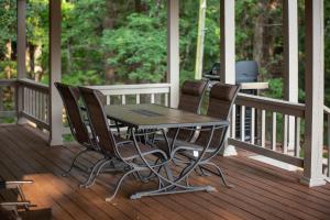 a table and chairs on a porch with a grill at Oxford Hillside Hideaway in Oxford