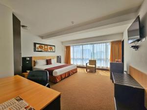 Una habitación de hotel con una cama y una ventana grande. en Allpa Hotel & Suites, en Lima