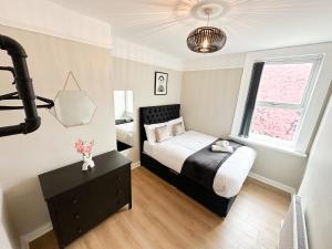 um pequeno quarto com uma cama e uma janela em Brand New Modern Boutique Home em Liverpool