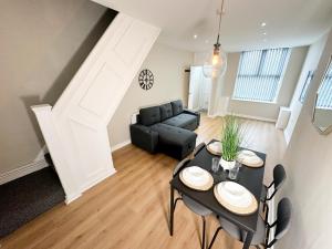 una sala de estar con una mesa y un sofá en 2 Bedroom house 10 mins to City Centre & Albert Dock, en Liverpool