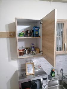 eine kleine Küche mit einer Spüle und einer Mikrowelle in der Unterkunft Στουντιο Βολος Ν Ιωνια in Volos