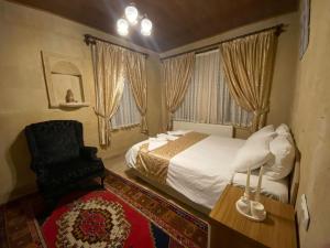 1 dormitorio con 1 cama y 1 silla en Arnovalley Hotel en Urgup