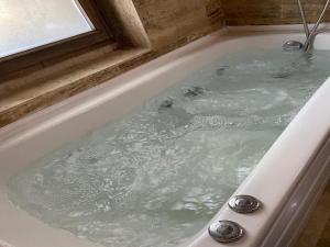a bath tub filled with water with a window at Arnovalley Hotel in Urgup