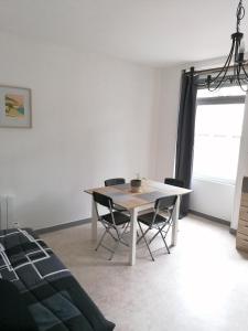 Appartement-Vierzon-centre في فييرزو: غرفة طعام مع طاولة وكرسيين