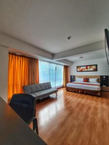 a large bedroom with a bed and a couch at Allpa Hotel & Suites in Lima