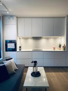 cocina con armarios blancos y mesa de centro en Mycondo no - Ø. Langgt 6, en Tønsberg