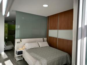 ラスパルマス・デ・グランカナリアにあるOlof Apartmentの木製の壁のベッドルーム1室(ベッド1台付)
