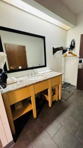 a bathroom with a sink and a large mirror at Baymont by Wyndham Chicago/Calumet City in Calumet City