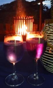 two wine glasses sitting on a table with a candle at Thalassa's in Port Shepstone