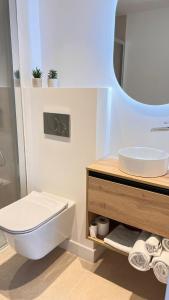 a bathroom with a toilet and a sink and a mirror at Olcina apartments in El Castell de Guadalest