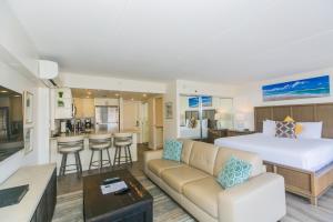 ein Hotelzimmer mit einem Bett und einem Wohnzimmer in der Unterkunft Ilikai Tower 1717 City View 1BR in Honolulu