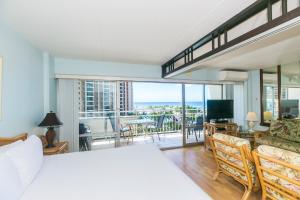 a bedroom with a large bed and a living room at Ilikai Tower 720 Lagoon View 1BR in Honolulu