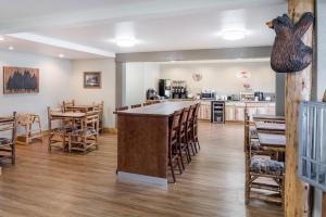 een kamer met een bar en een aantal tafels en stoelen bij Super 8 by Wyndham Kalispell Glacier National Park in Kalispell