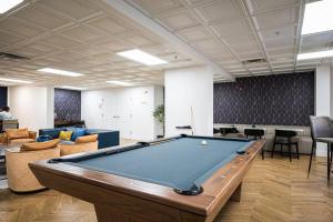 a pool table in an office with chairs and a table at Class & Space Uptown in Charlotte