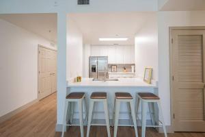 a kitchen with three bar stools and a counter at Class & Space Uptown in Charlotte