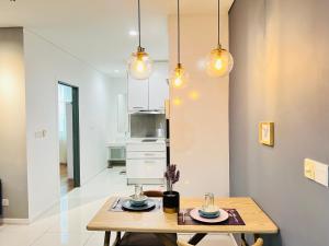 吉隆坡的住宿－Mercu Summer Suites KLCC By Sweet Home，一间设有桌子和一些灯的用餐室