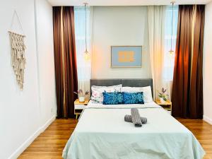 吉隆坡的住宿－Mercu Summer Suites KLCC By Sweet Home，卧室配有带蓝色枕头的大型白色床