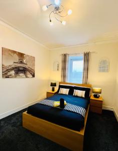 a bedroom with a bed and a picture of the eiffel tower at Cosy Apartment Glasgow Airport in Paisley