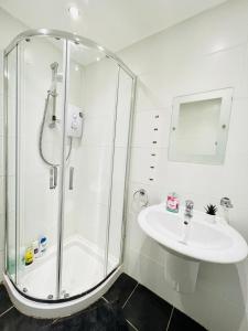 a white bathroom with a shower and a sink at Cosy Apartment Glasgow Airport in Paisley
