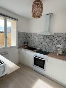 cocina con armarios blancos y fogones en Petite maison cosy en campagne, en Neuilly