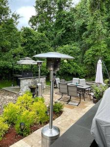 une terrasse avec un parasol, une table et des chaises dans l'établissement The Oasis@Woodyard, à Upper Marlboro