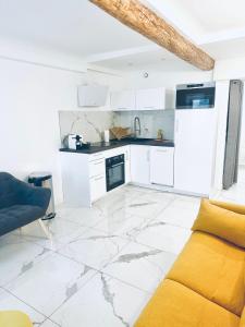 eine Küche mit weißen Schränken und einer gelben Couch in der Unterkunft T3 carré d’or plein centre in Nizza