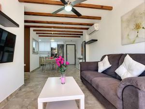 a living room with a couch and a table with flowers at 3 bed ground first floor apartment. Close to beach in Mar de Cristal