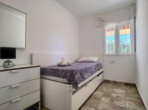 a white bedroom with a bed and a window at 3 bed ground first floor apartment. Close to beach in Mar de Cristal +17 photos